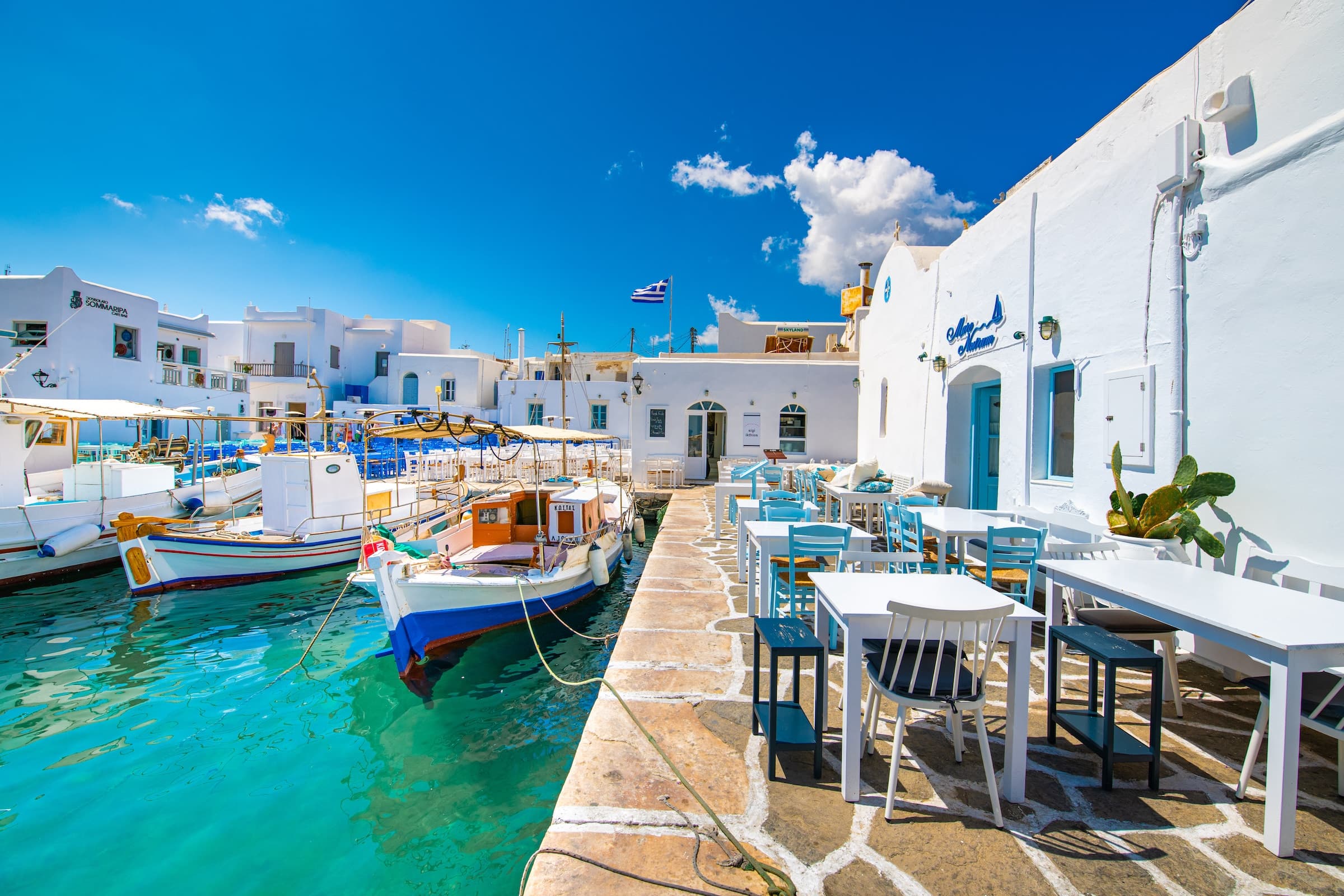 Fishing boats and waterfront tables in Naoussa harbour, Paros